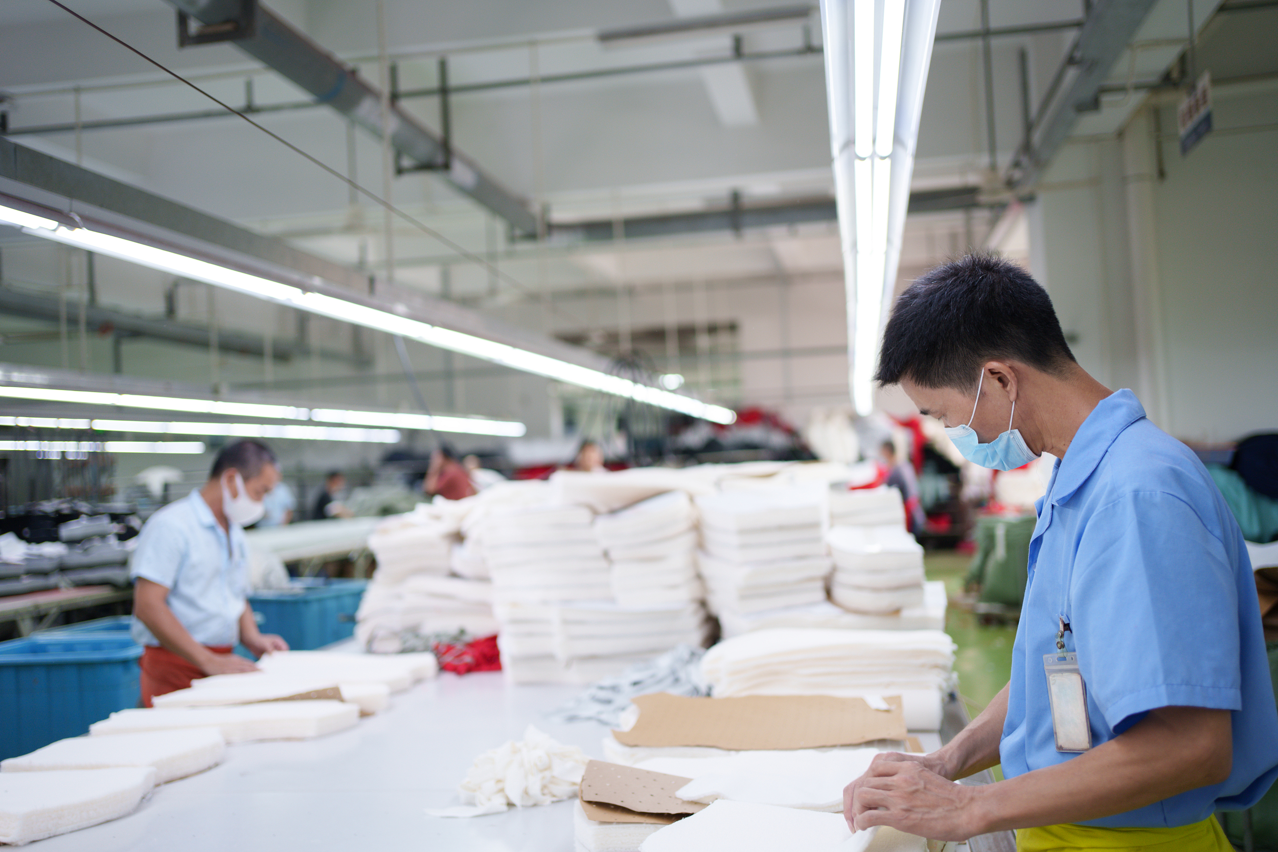 Ouvriers travaillant dans un atelier de découpe de tissus en Chine