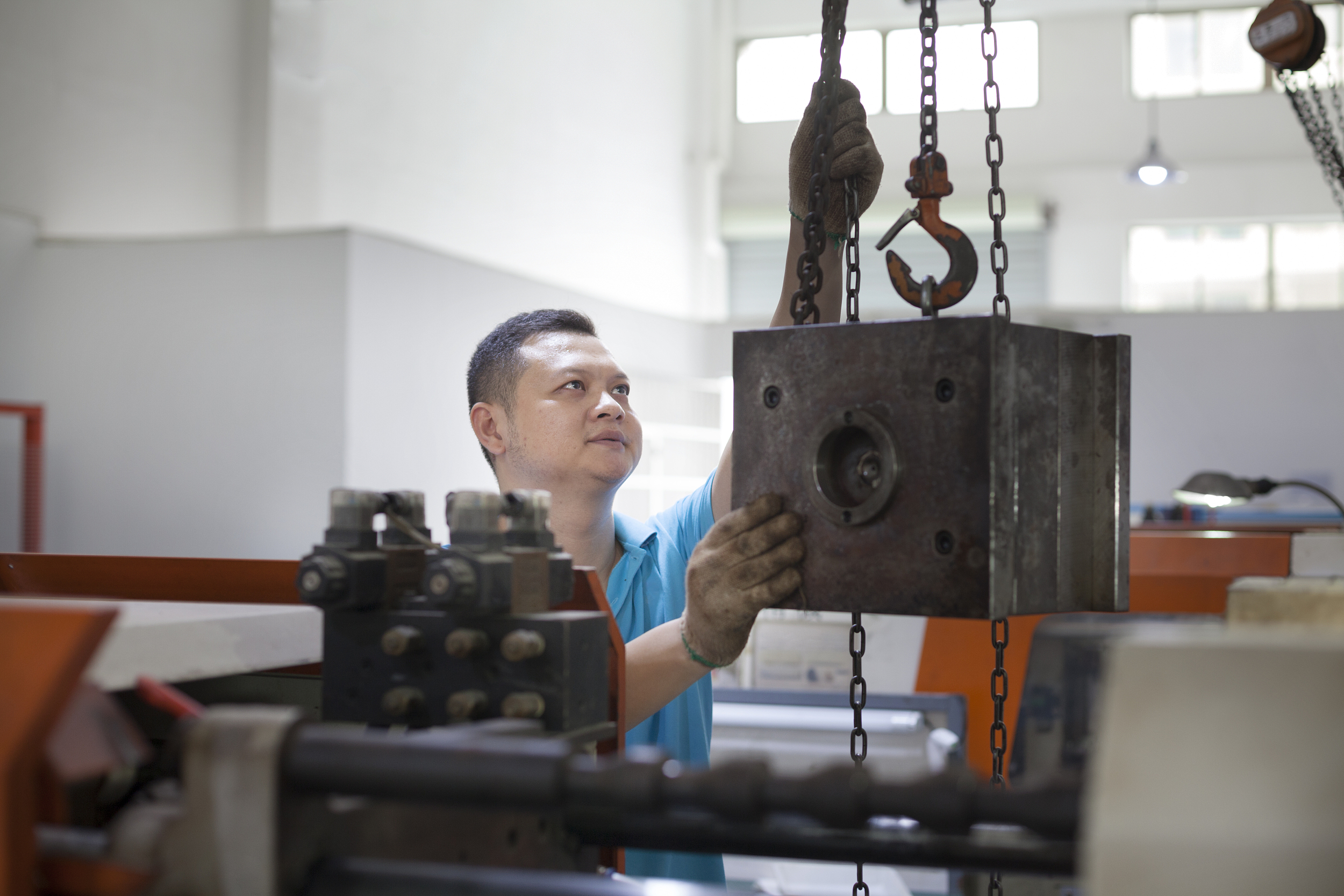 Technicien ajustant un équipement lourd dans une usine de fabrication en Chine